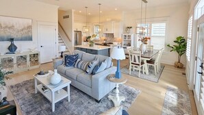 A spacious living room with a grey sofa, a coffee table, and a dining area with a table and chairs. - Perfect Getaway Near Ocean City’s Famous Gold Coast (Ocean City)