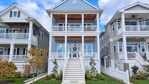 A two-story residential building with a central entrance, a balcony on the upper floor, and a staircase leading to the entrance. - Perfect Getaway Near Ocean City’s Famous Gold Coast (Ocean City)