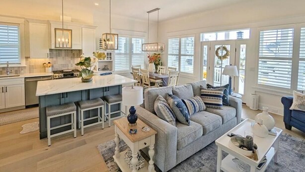 A spacious living area with a large gray sofa, a dining table, and a kitchen island. - Perfect Getaway Near Ocean City’s Famous Gold Coast (Ocean City)