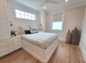 A bedroom with a bed, nightstands, a dresser, a window, and two decorative vases. - Luxury Coastal Retreat – Close to Beach, Boardwalk & Dining (Ocean City)