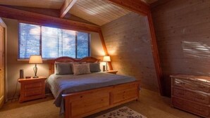 A cozy bedroom with a wooden bed, nightstands, and a dresser. -  Inviting Central Oregon Escape (Sunriver)