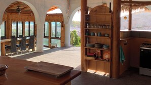 A rustic interior with a thatched roof, wooden furniture, and a view of the outdoors. - Unique villa 400 m from secluded beach with panoramic views, reached by 4x4 (Baja California Sur)