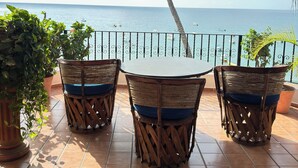 Una terraza con mesa y sillas, con vistas al mar.