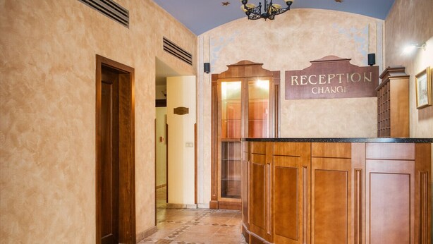 Una zona de recepción con un cartel que dice "RECEPTION CHANCE" y una barra de madera.