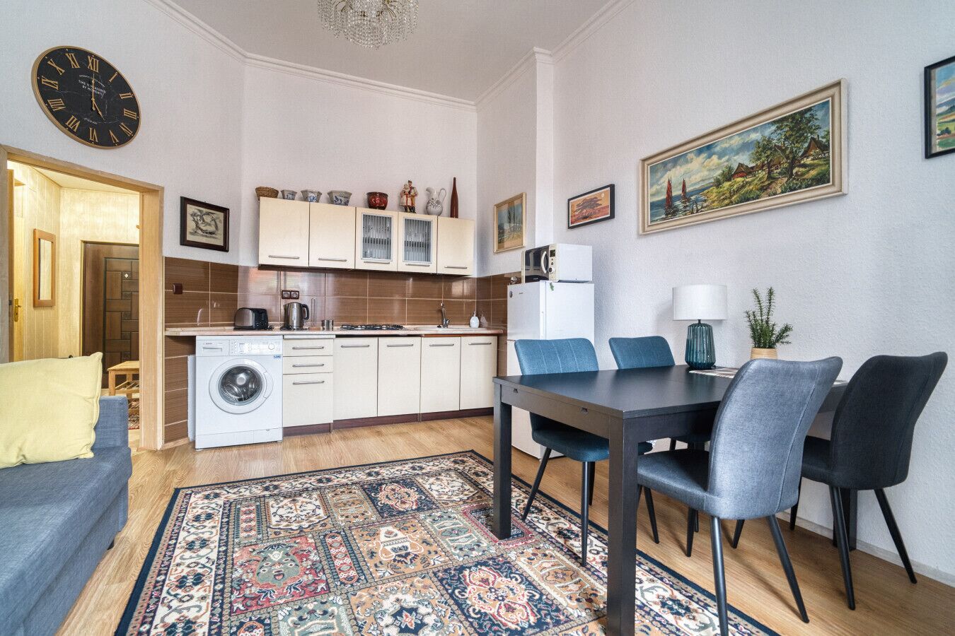 Un ambiente compatto con angolo ristoro, cucina e lavatrice.