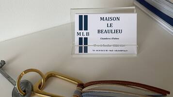 Naambordje met 'MAISON LE BEAULIEU' en een sleutel met sleutelhanger.