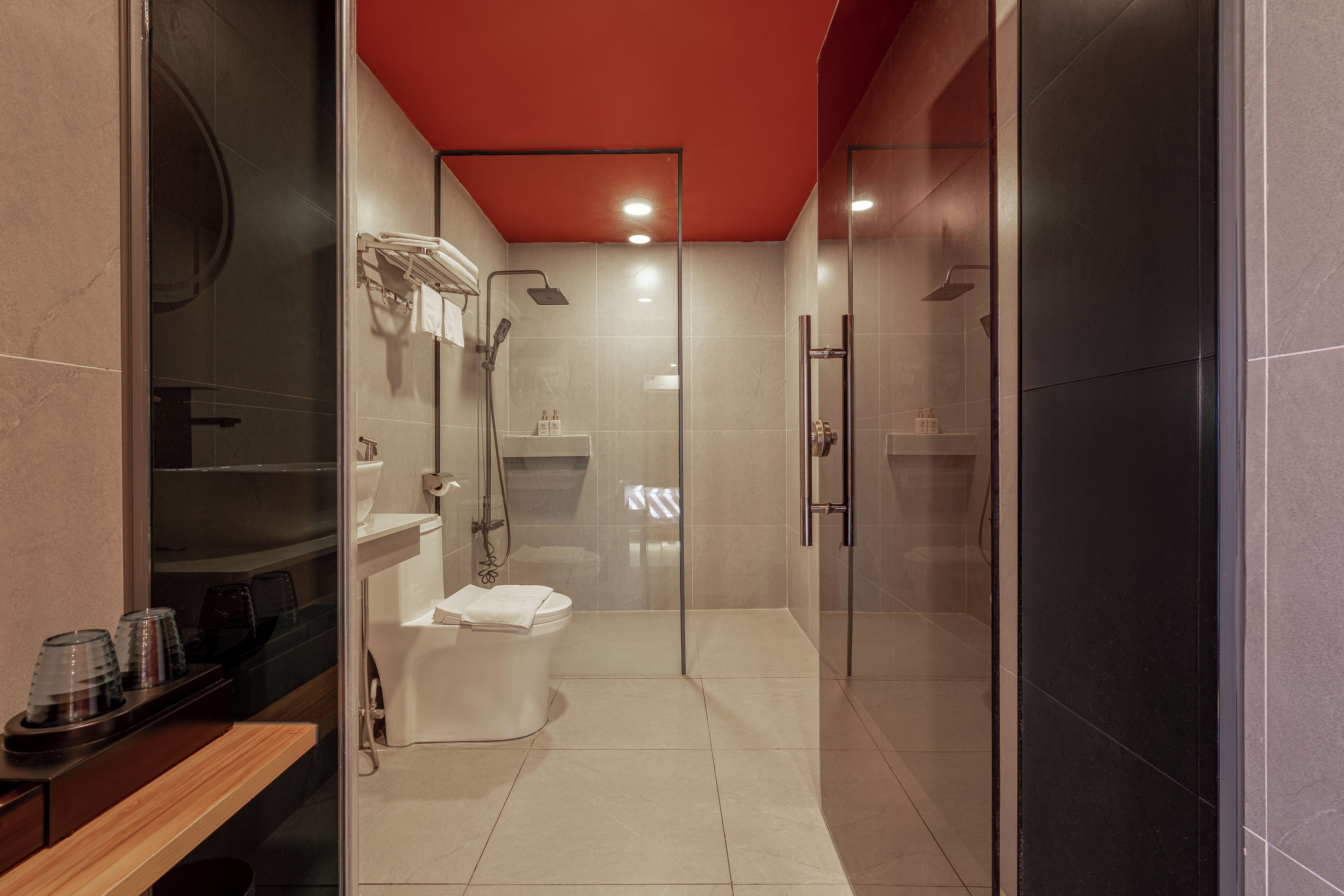 Un bagno moderno con cabina doccia in vetro, un water e un lavandino.