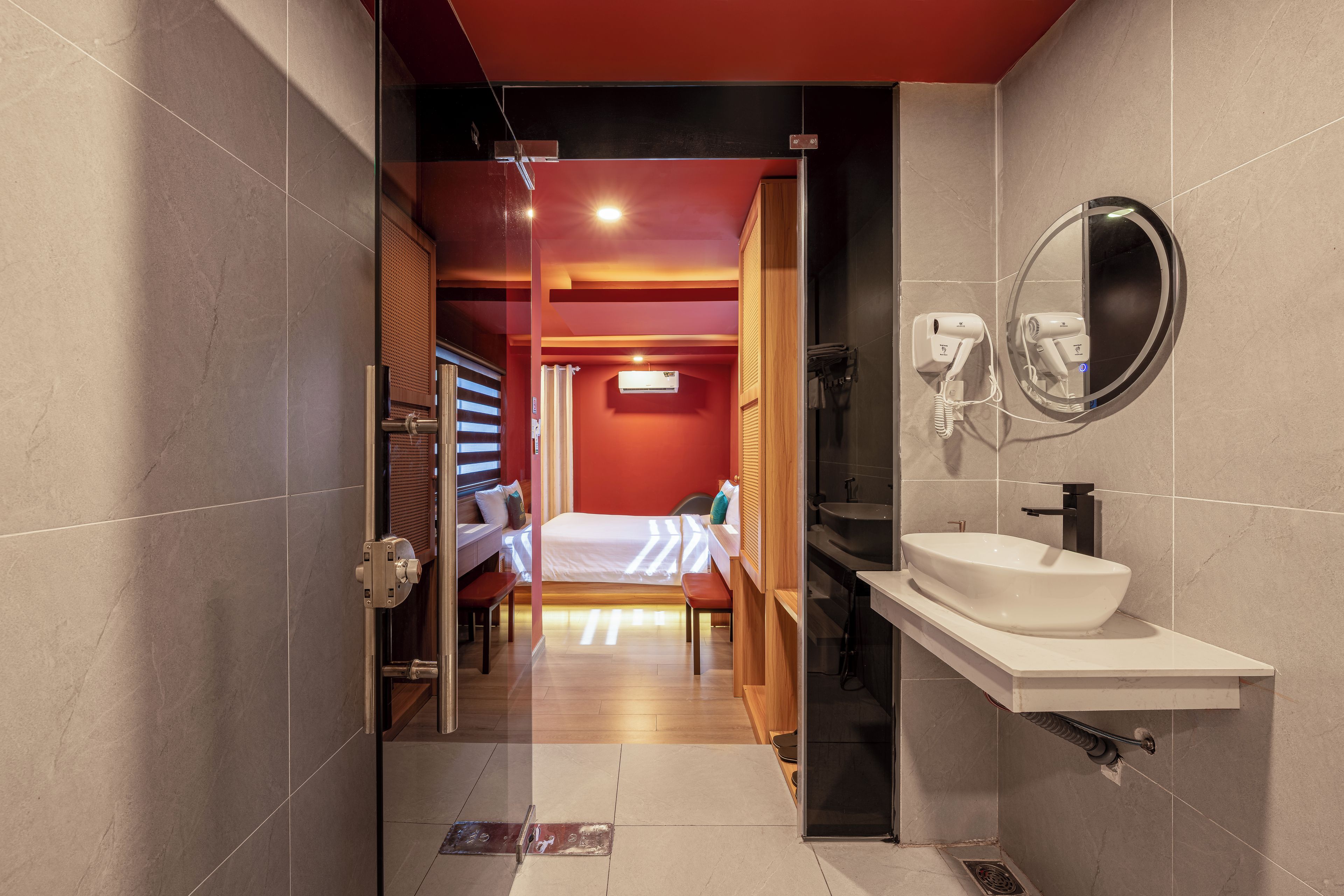 Ein modernes Badezimmer mit einem großen Waschbecken, einem Spiegel und einem Föhn.