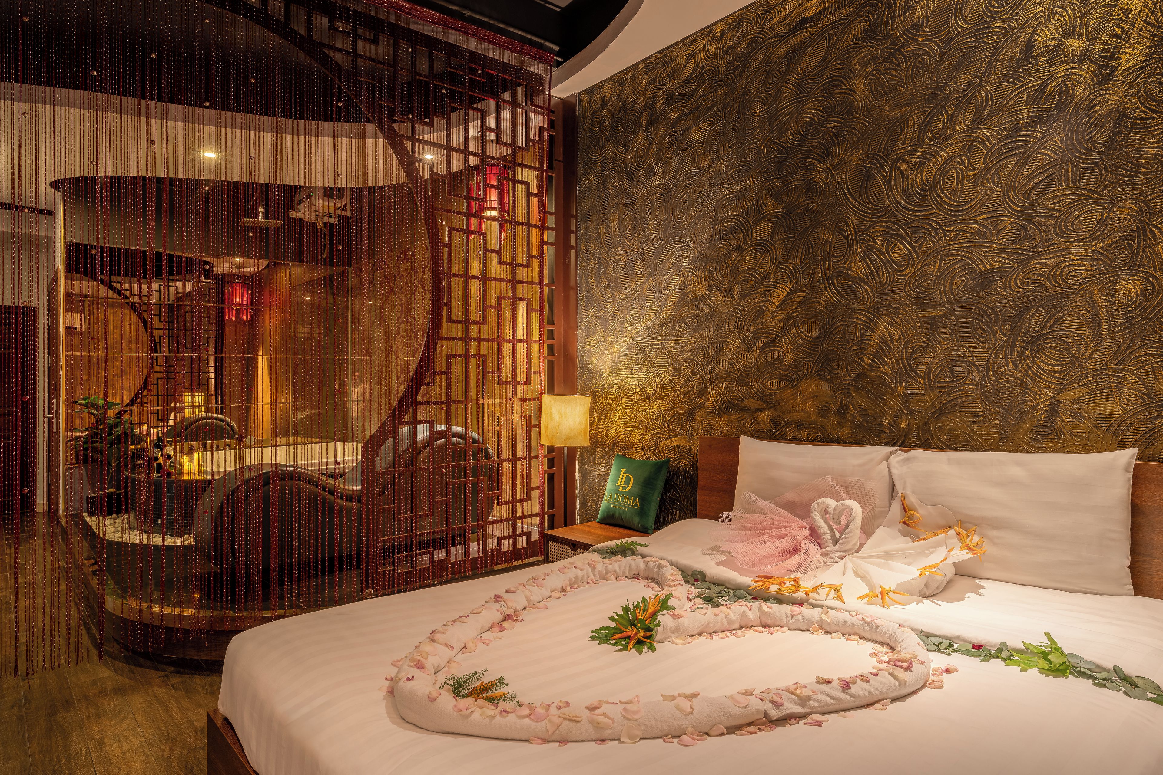 Une chambre d’hôtel avec un lit, une table de chevet, un mur décoratif et une vue sur l’extérieur.