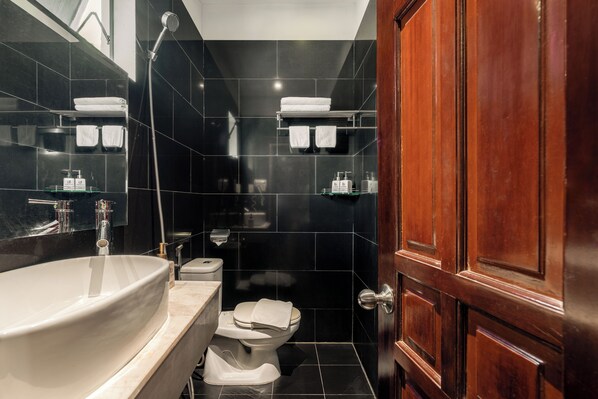 A bathroom with a large white sink, a toilet, and a shower area. - La Doma en Amour Hotel (Ho Chi Minh City)