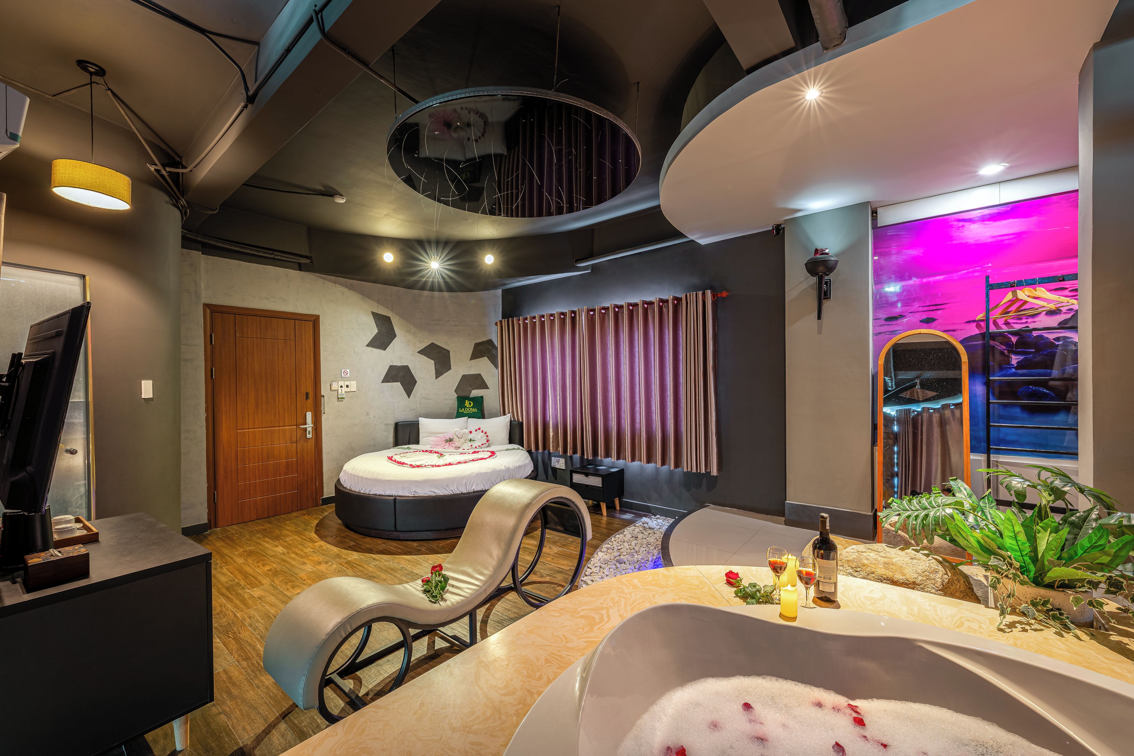 A modern spa room with a bathtub, a massage chair, and a large mirror.