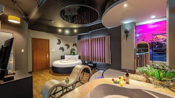 A modern spa room with a bathtub, a massage chair, and a large mirror.