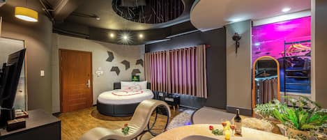 Een moderne spa ruimte met een badkuip, een massagestoel en een grote spiegel.