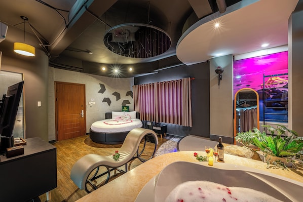 A modern spa room with a bathtub, a massage chair, and a large mirror. - La Doma en Amour Hotel (Ho Chi Minh City)