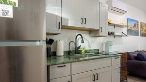 Une cuisine moderne dotée d’appareils électroménagers en acier inoxydable, d’un plan de travail en marbre et d’un évier encastré.