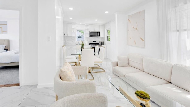A modern living room with a sofa, armchairs, a coffee table, and a dining area with a table and chairs. - Two Wash (Yonkers)
