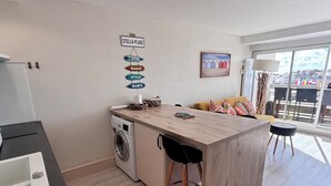 Een moderne keuken met een centraal eiland, een wasmachine en een eetgedeelte met uitzicht.