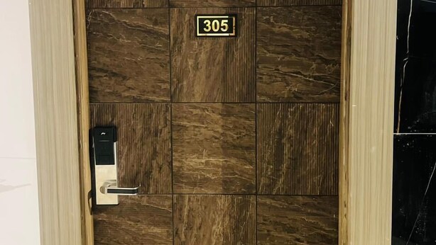 A wooden door with a number plate '305' and a keypad lock. - HOTEL SUPREME INN (Varanasi)