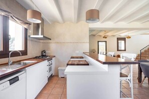 A modern kitchen with a central island, built-in appliances, and pendant lighting. - Rural house on the edge of the Verde river (Tibi)