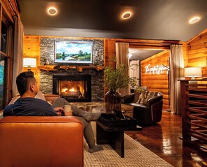 A cozy living room with a fireplace, comfortable seating, and a television. - Stonara • Lovers’Hideaway: Cliffside Hot Tub + Sauna + Cinema (Blue Ridge)