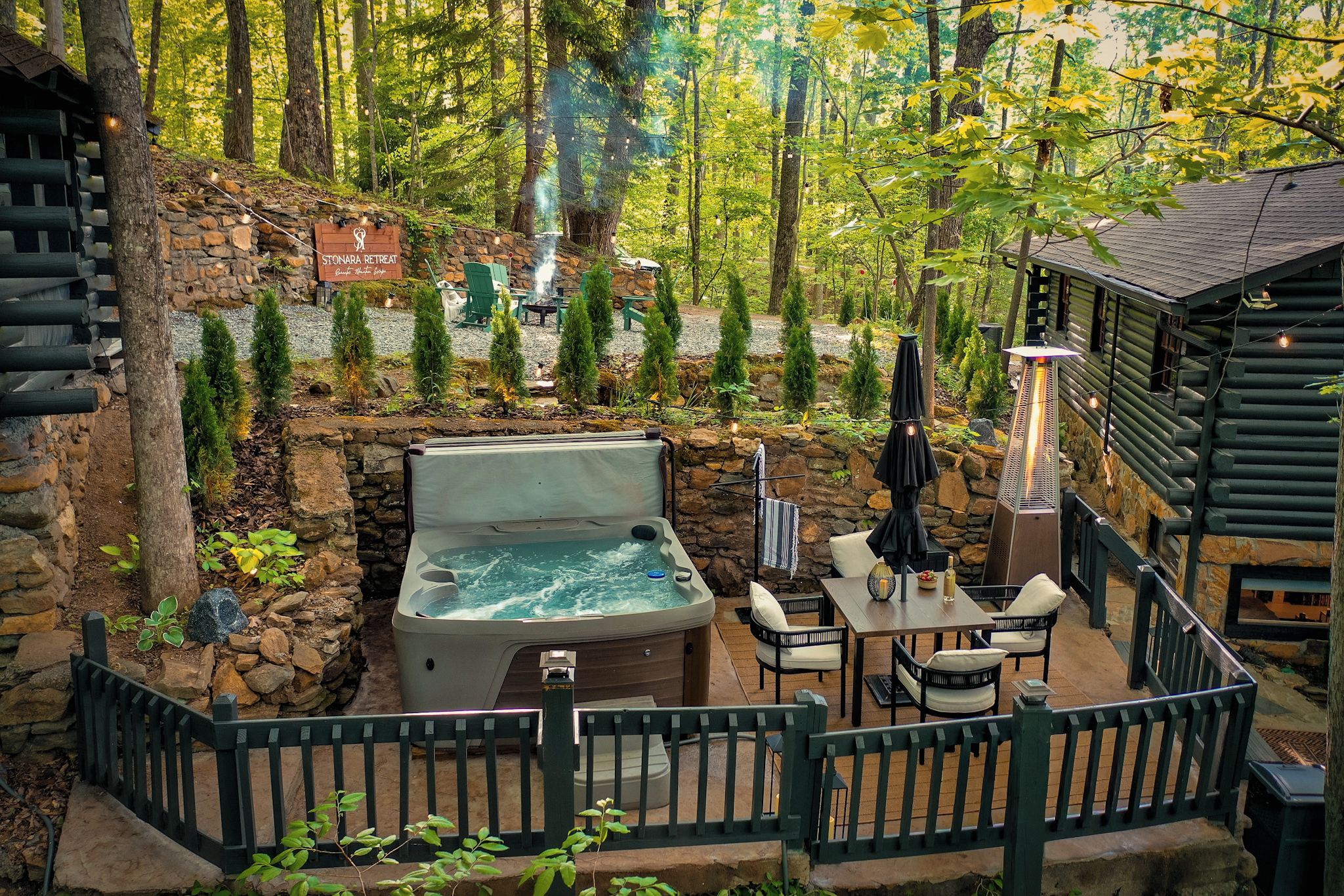 A hot tub, outdoor seating, a stone wall, and a sign for Stonara Retreat.