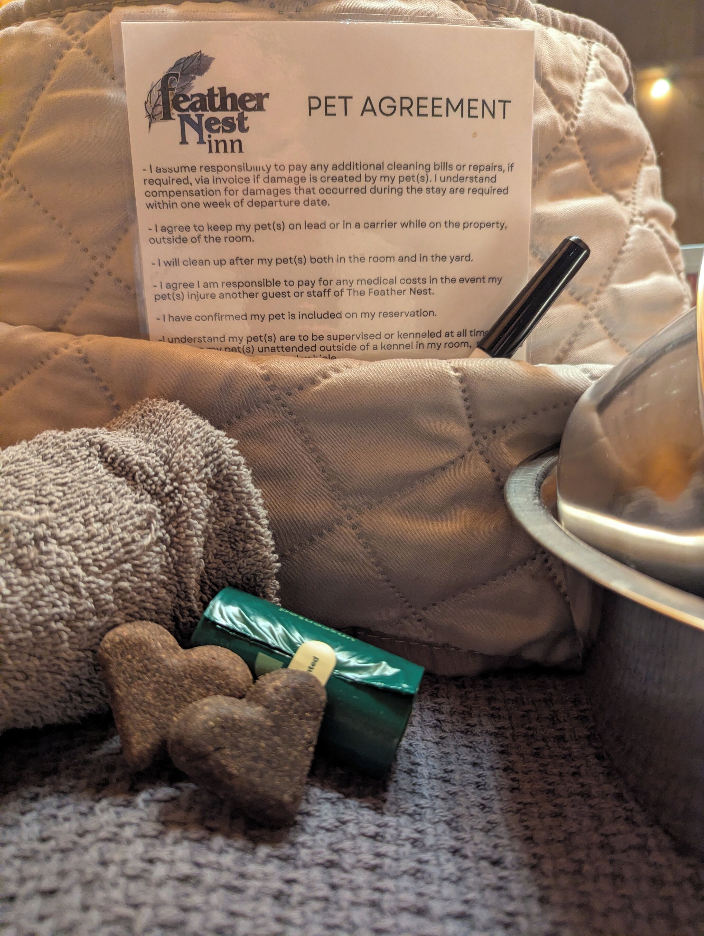 A pet bed with a feather nest pet agreement on it.