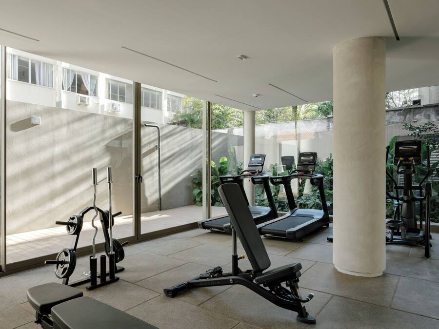 A gym with exercise equipment including treadmills, a bench press, and a squat rack.