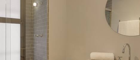 A modern bathroom with a shower, toilet, and sink.