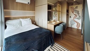 A modern hotel room with a bed, desk, and chair, a mirror, and a decorative wall. - SOMA PERDIZES 908 (São Paulo)