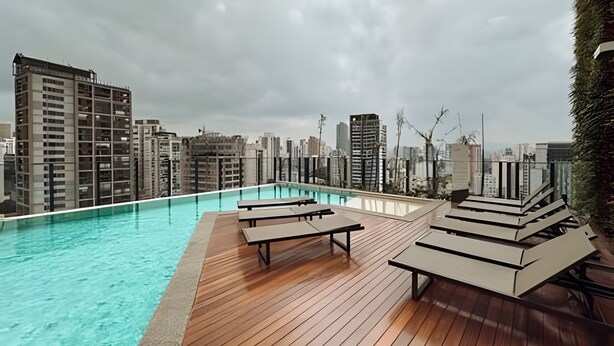 A rooftop pool area with lounge chairs and a city skyline view. - SOMA PERDIZES 908 (São Paulo)