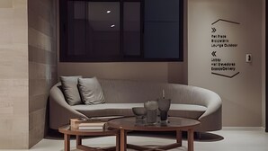 A modern living room with a sofa, two coffee tables, and a wall-mounted TV. - SOMA PERDIZES 908 (São Paulo)