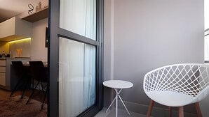 A modern interior with a dining area, a white chair, and a small table. - SOMA PERDIZES 908 (São Paulo)