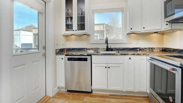 A kitchen with white cabinets, a dishwasher, a stove, and a window. - Quiet / River / Bike Bath (Salida)