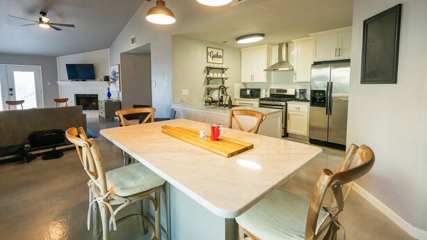 A spacious kitchen with modern appliances, a dining area with a wooden table, and a living area with a sofa and chairs. - Lux Home MINS to NE Baptist Hospital & TPC San Antonio/ Sleeps 4 (San Antonio)