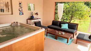 Ein Spa-Raum mit Whirlpool, einer Sitzecke und einem kleinen Tisch.