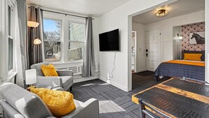 Un hotel moderno con sofá, cama, televisión y vistas al exterior.