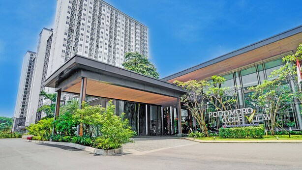 A modern building with a prominent entrance, large windows, and a sign reading "PODOMORO GOLF VIEW". - OYO 95052 Cordia Tower (Gunung Putri)