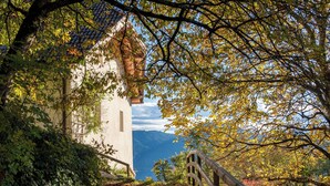 A castle with a tower, surrounded by trees and a mountain in the background. - Idyllic apartment on the Ritten - peace, nature & views of the Dolomites. Mobilcard incl (Trentino-Alto Adige)
