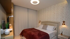 Une chambre avec un grand lit, une table de chevet avec une lampe et un miroir au mur.
