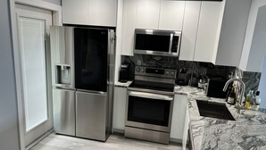 A modern kitchen with stainless steel appliances, a built-in oven, and a microwave. - Cozy 1-bedroom condo in peaceful Hallandale Beach with AC (Hallandale Beach)