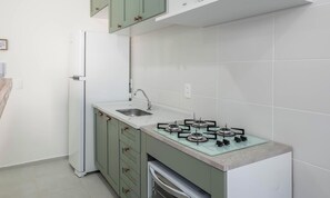 A kitchen with a built-in gas stove, a sink, and a white refrigerator. - Apart w/ BBC 750 m From the Beach Sfr0411 (Barra Velha)