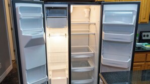 Una cocina moderna con refrigerador integrado, estufa y armarios de madera.