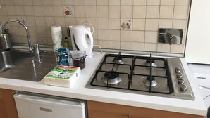 A kitchen with a gas stove, a sink, and a dishwasher. - Lovely studio apartment in the heart of the historic center of Rome (Roma)