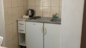 A compact kitchenette with a stove, kettle, sink, and cabinets. - Apartments Adriana Studio apartment 8 (Podaca)