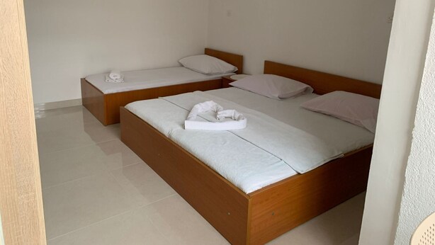 A hotel room with two wooden beds, each with white linens and pillows, and a small bedside table with a lamp. - Apartments Adriana Studio apartment 8 (Podaca)