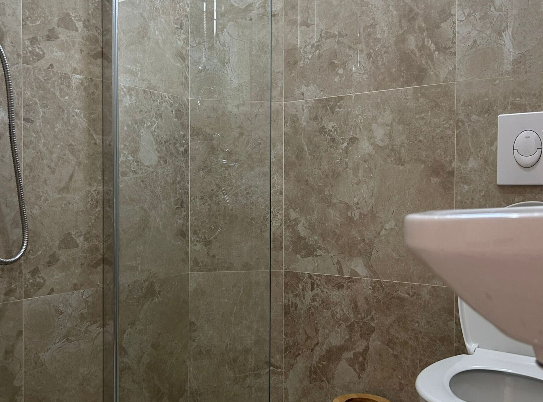 Une salle de bain comprenant un espace douche, des toilettes et un panneau de commande.