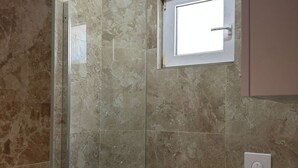 A bathroom with a glass shower enclosure, a small window, and a toilet. - Apartments Adriana Studio apartment 4 (Podaca)