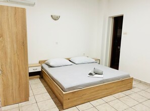 A bedroom with a wooden bed, two pillows, a bedside table, and a nightstand. - Apartments Adriana - Two bedroom Apartment 9 (Podaca)