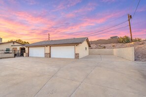 A two-story building with a garage and a paved driveway.