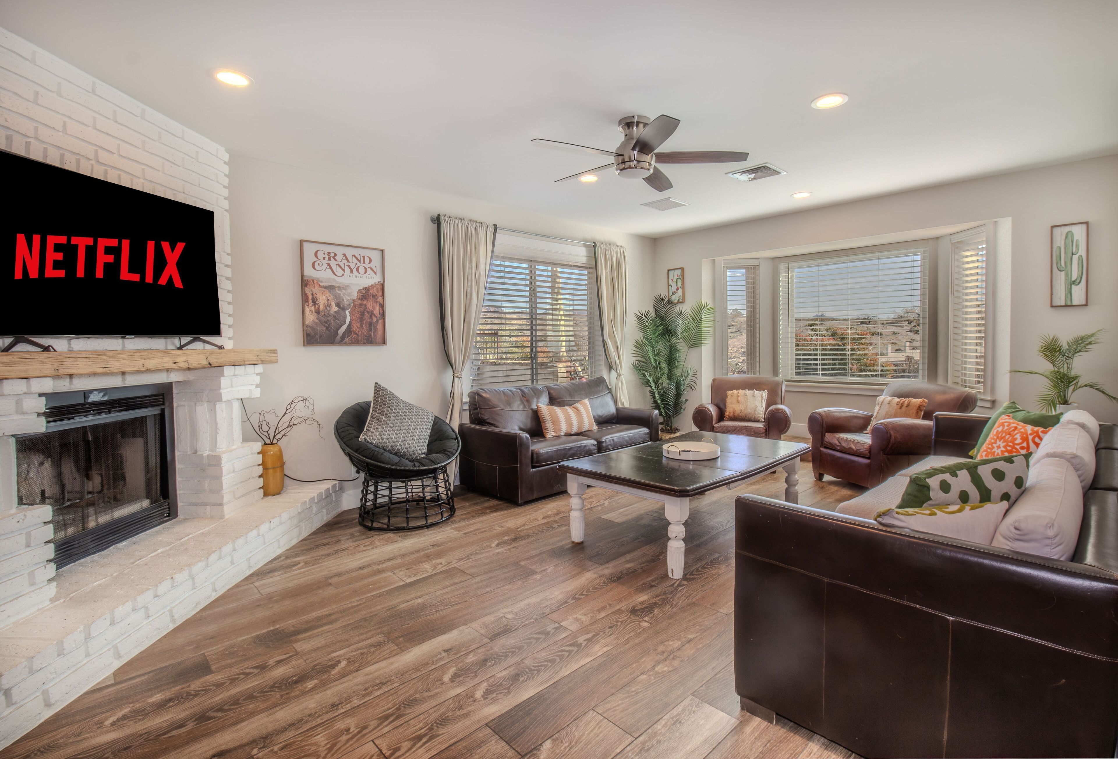 Ein Wohnzimmer mit Kamin, Ledersofas, einem Couchtisch und einem Fernseher, der 'NETFLIX' zeigt.